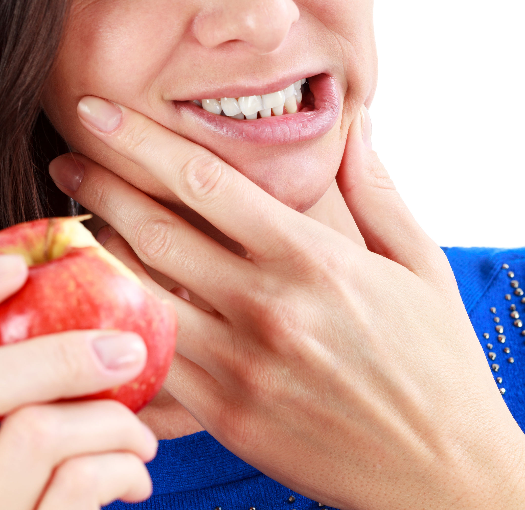 woman holding hands to jaw after eating apple with jaw pain<br />
